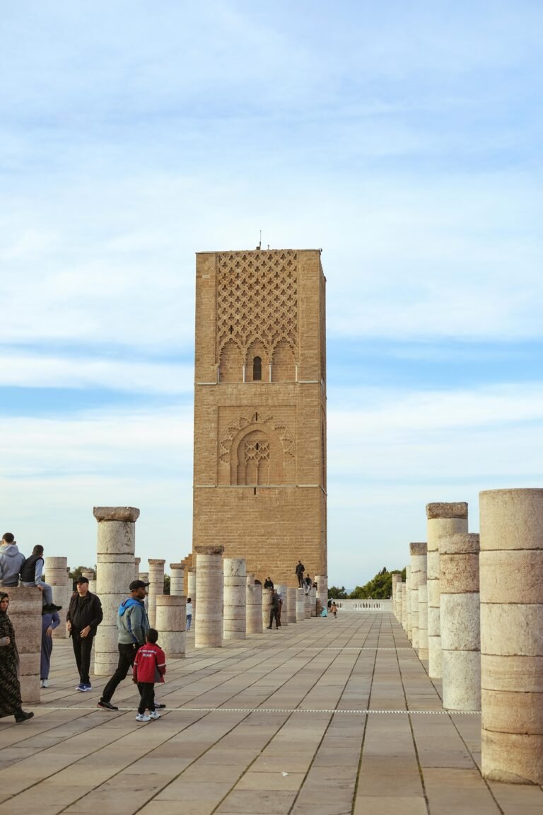 A scenic view of Hassan Tower with visitors exploring the historic site in Rabat, Morocco.